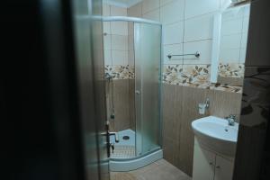 a bathroom with a shower and a sink at Pensiunea La Lenuta in Onceşti