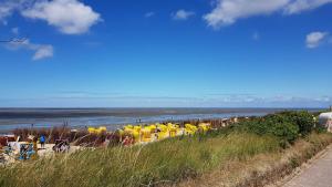 een groep gele parasols op het strand bij Residenz Trossenstek in Cuxhaven