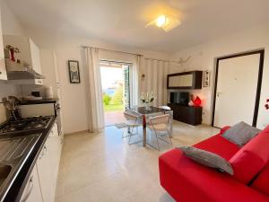 een keuken en een woonkamer met een rode bank bij Casa Amalfi Zambrone Madama in Torre SantʼIrene