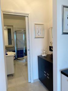 een badkamer met een douche, een wastafel en een spiegel bij Casa Amalfi Zambrone Madama in Torre SantʼIrene
