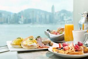 a table with two plates of breakfast foods and orange juice at InterContinental Grand Stanford Hong Kong, an IHG Hotel in Hong Kong