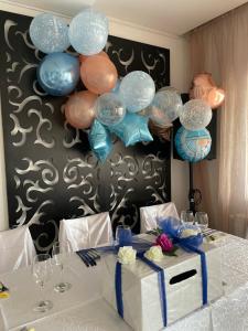 a table with a bunch of balloons and a box at Vila Club Dioda in Cicanesti +68 photos