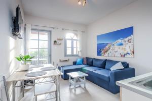 sala de estar con sofá azul y mesa en Calma Luxury Apartments #2 Sozopoli in Halkidiki, en Sozopoli