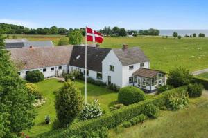 una casa con una bandera canadiense encima en Idyllisk gård med ro, plads og havudsigt, en Hesselager
