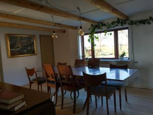 a dining room with a wooden table and chairs at Idyllisk gård med ro, plads og havudsigt in Hesselager +19 photos