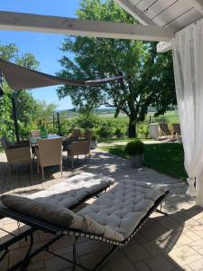 acovered patio with a bench and a table and chairs at Szőlőskert vendégház in Balatonszőlős