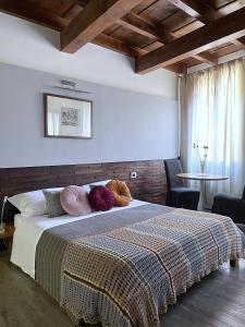 Un dormitorio con una cama grande con almohadas. en Alkimia Smart Rooms, en Ferrara