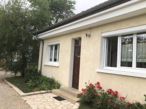 a house with a door and a window and flowers at Halte Saltusienne in Saint-Julien-du-Sault