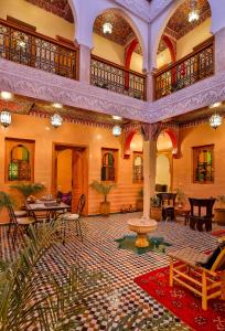 une grande salle avec des tables et des chaises ainsi qu'une fontaine dans l'établissement RIAD VILLA SIDI BABA, à Marrakech