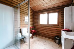 a bathroom with a glass shower in a log cabin at Bij de Appelhof in Valkenswaard