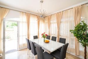 a dining room with a white table and chairs at Holiday Home King in Dubrovnik