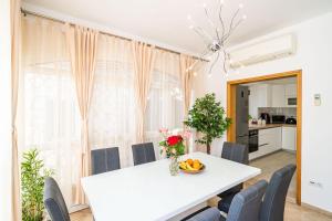 ein Esszimmer mit einem weißen Tisch und Stühlen in der Unterkunft Holiday Home King in Dubrovnik