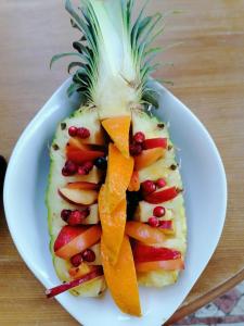 a white plate with a pineapple cut in half with fruit at Les studios du Domaine d'Eva in Libramont +11 photos