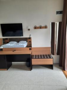 1 dormitorio con escritorio, TV y cama en Бутикови Студиа БРИТА en Kranevo