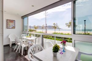 a balcony with tables and chairs and a view of the beach at Residence de la Plage Roses - Immo Barneda in Roses