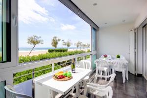 a balcony with a table and chairs and a view of the beach at Residence de la Plage Roses - Immo Barneda in Roses