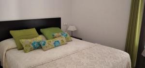 - une chambre dotée d'un lit avec des oreillers verts et jaunes dans l'établissement Petit Hotel Porrera, à Porrera