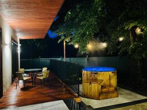 a wooden deck with a table and a blue tub at WRZOS resort & wellness **** DOMKI CAŁOROCZNE in Węgierska Górka