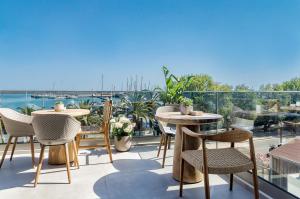 a patio with tables and chairs on a balcony at SAVUS Boutique Hotel in Rethymno