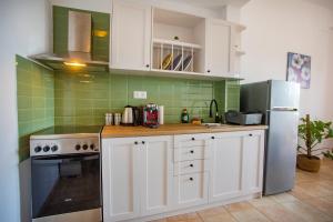 a kitchen with white cabinets and a refrigerator at Notos Sea Front Apartment in Glossa +7 photos