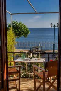 a table and chairs on a balcony with a view of the ocean at Notos Sea Front Apartment in Glossa