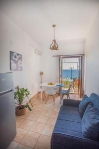 a living room with a blue couch and a table at Notos Sea Front Apartment in Glossa