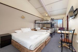 a bedroom with a bed and a bunk bed at Snowy Gums Smiggins in Perisher Valley
