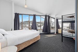 a bedroom with two bunk beds and a window at Snowy Gums Smiggins in Perisher Valley