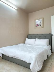a bedroom with a large bed with white sheets at Homestay Wafiy Lost World Tambun Ipoh in Ipoh