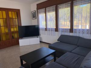 a living room with a couch and a flat screen tv at Mas Tauler in Sant Antoni de Calonge