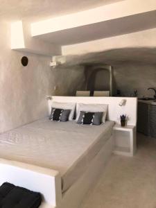 a white bedroom with a large white bed with pillows at Salty Kisses and Sandy Toes in Firopótamos