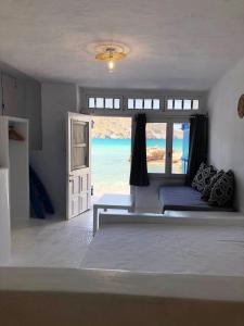 a bedroom with a bed with a view of the ocean at Salty Kisses and Sandy Toes in Firopótamos