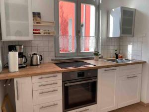 a kitchen with white cabinets and a stove top oven at Ferienwohnung Lavendel in Waren