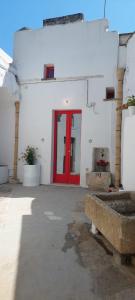 een rode deur in een wit gebouw met een rode deur bij Corte SantAngelo 15 in Tricase