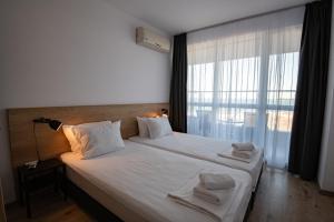 a bedroom with a large bed with a large window at Aparthotel Primorsko in Primorsko +165 photos