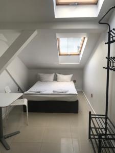 a small bedroom with a bed and a window at Hoża Apartments and Rooms in Warsaw