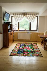 a room with a rug on the floor with a window at Cabana Barlogul Lupilor in Berevoeşti
