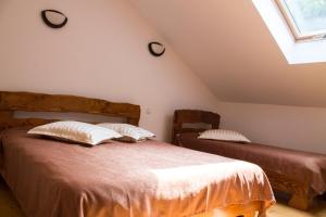 a bedroom with two beds in a attic at Cabana Barlogul Lupilor in Berevoeşti