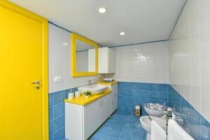 baño azul y blanco con lavabo y aseo en Freedom, en Santa Maria di Castellabate