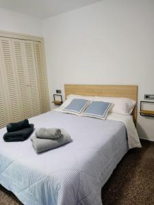 Un dormitorio con una cama blanca con dos libros. en Apartament Edifici Simbat a 150m de la platja, en Palamós