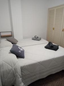 Una cama blanca con dos toallas encima. en Apartament Edifici Simbat a 150m de la platja, en Palamós
