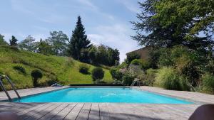 a swimming pool in a garden with a wooden deck at Maison familiale de charme in Chalabre