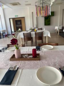 a table with white plates and utensils in a restaurant at Hotel Alpex in Zabrze
