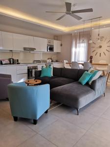 un salon avec un canapé et une cuisine dans l'établissement PEREYBERE -Charming 2 bedrooms apartment- WITH POOL - BEACHCOVE Apartments, North Living, APT 8, à Pereybere