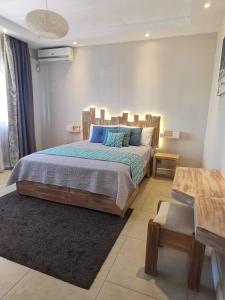 une chambre avec un grand lit avec des oreillers bleus dans l'établissement PEREYBERE -Charming 2 bedrooms apartment- WITH POOL - BEACHCOVE Apartments, North Living, APT 8, à Pereybere