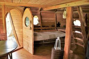 sypialnia z łóżkiem w drewnianym domku w obiekcie Cabane Perchée dans les Arbres w mieście Saint-Hilaire-en-Morvan