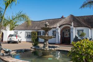 a fountain in front of a house at The Sanctuary Guest House Estate in Cape Town