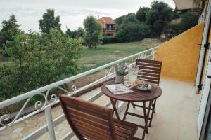 a table and chairs on a balcony with a view at Pagonia Apartments in Arillas +8 photos