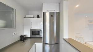 a kitchen with a stainless steel refrigerator and a microwave at Quiet en montemar in Torremolinos