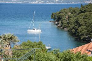 una barca a vela in un fiume con alberi sulla riva di Apartments Gorana a Splitska